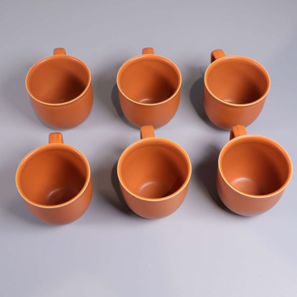 Överblick ovanifrån av sex orangea kaffekoppar