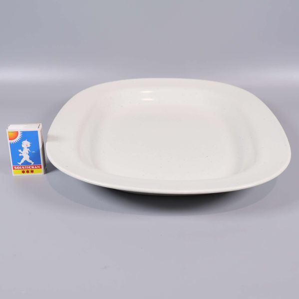 Vitt serveringsfat bredvid tändsticksask för storleksjämförelse