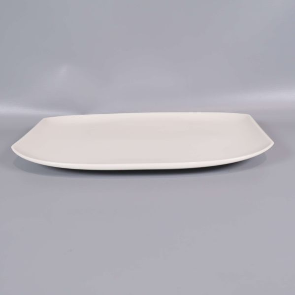 En rektangulär vit tallrik sett från sidan