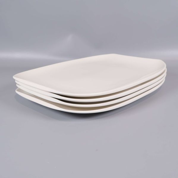 Fyra vita tallrikar liggande i sned vinkel