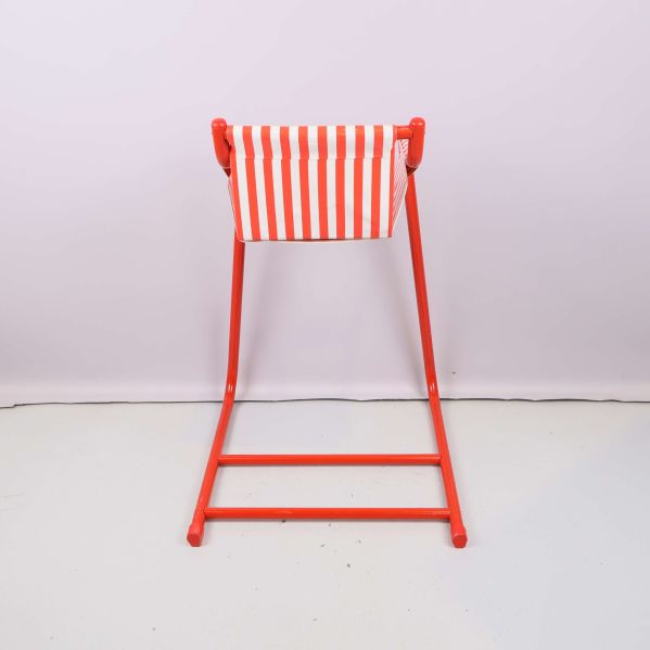 Baksidan på barnstol med röda detaljer och randig rygg