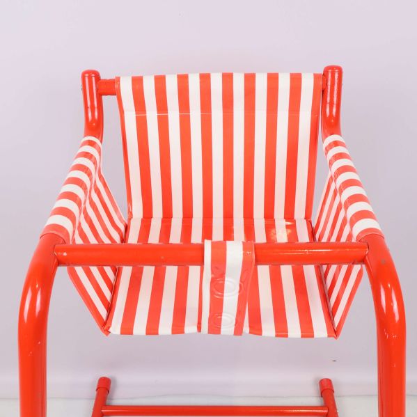 Närbild på randig sits i rött och vitt samt röda armar