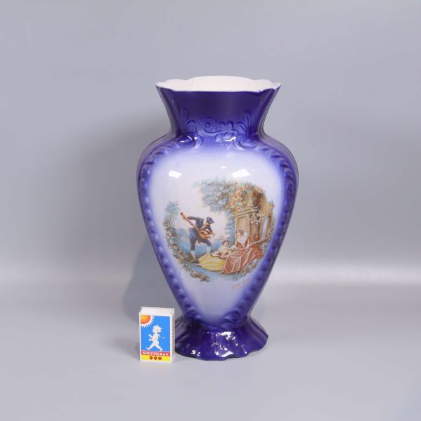 Vas jämte tändsticksask för storleksjämförelse och motiv på andra sidan