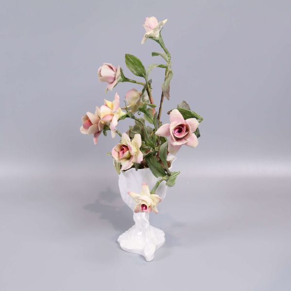 Porslinsvas med konstblommor sedd från sidan