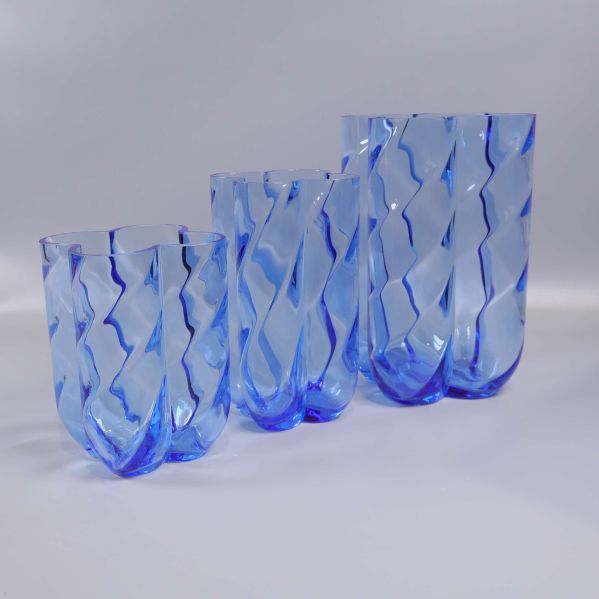 Sida av tre blå glasvaser med spiralformade linjer