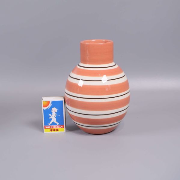 Randig vas jämte tändsticksask för storleksreferens