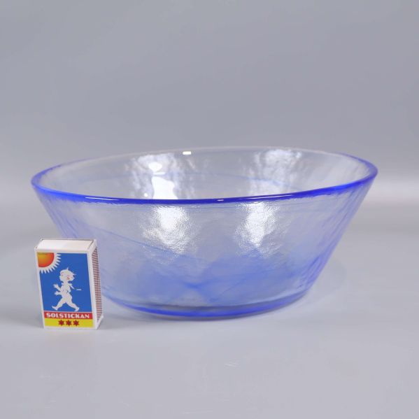 Blå och transparent glasskål med tändsticksask som storleksjämförelse