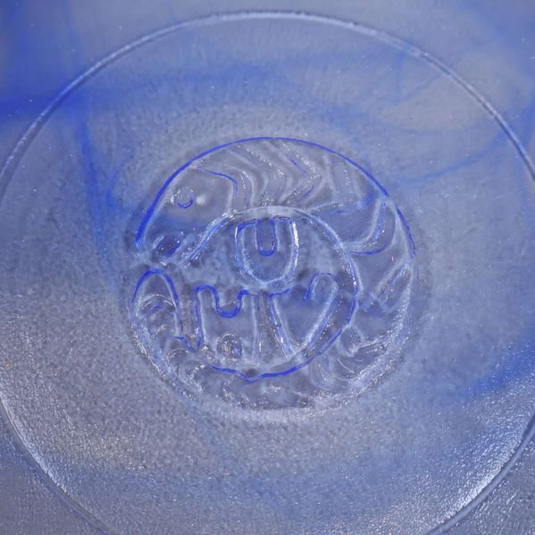 Detalj av botten på glasskål med präglat konstnärligt motiv (UHV)