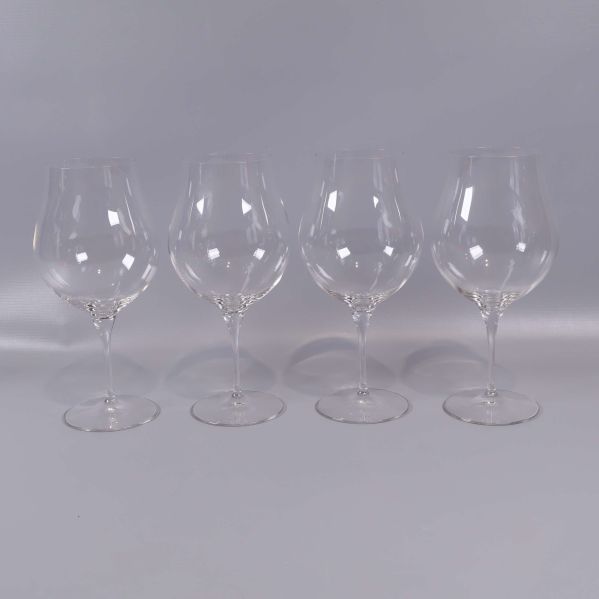 Fyra kupade vinglas på rad mot neutral bakgrund