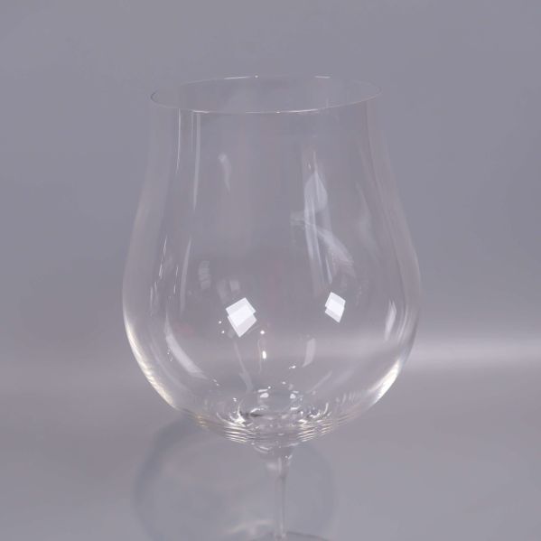 Närbild på ett vinglas med klar kupa och glasstjälk