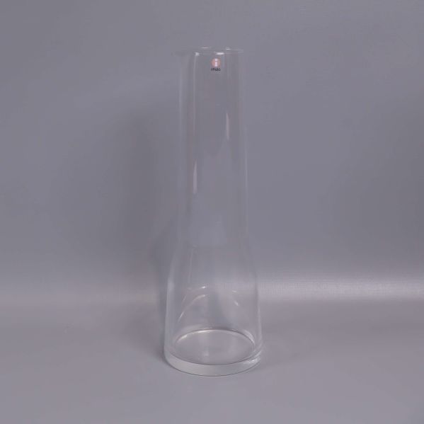 Hög smal karaff i klart glas mot grå bakgrund