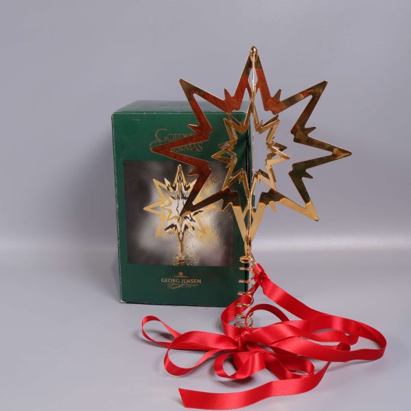 Guldfärgad topstjärna med röd rosett och kartong