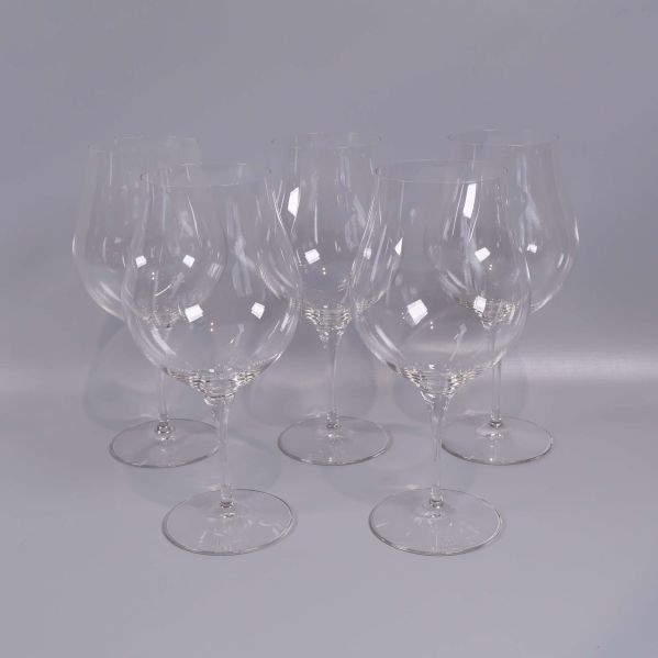 Fem vinglas uppställda mot ljus bakgrund