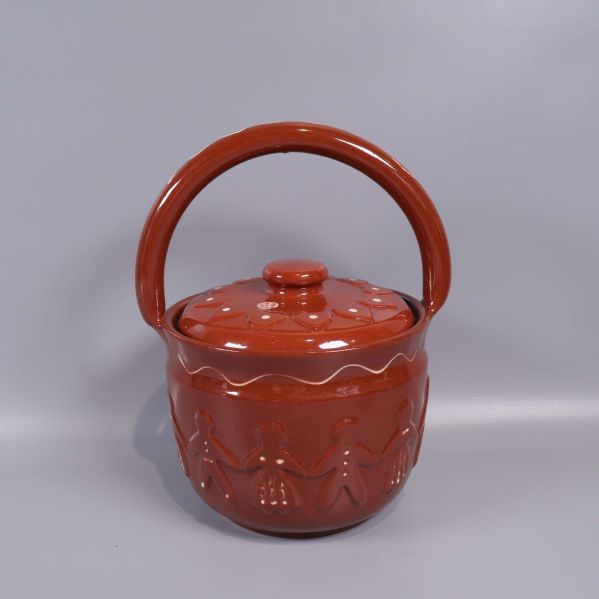 Brun keramikburk med lock och reliefdekor av figurer