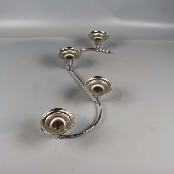 S-formad ljushållare i blank metall med fyra ljusplatser