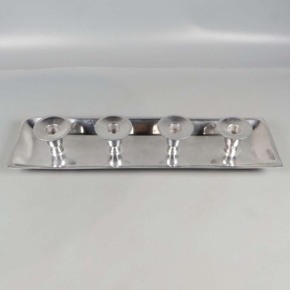 Ljusbricka i metall sedd rakt framifrån med fyra hållare