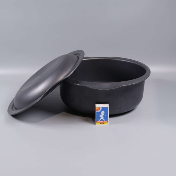 Svart gryta med öppet lock och tändsticksask