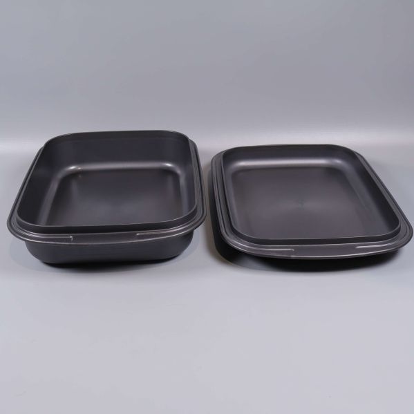 Två ugnsformar i svart plastmaterial bredvid varandra
