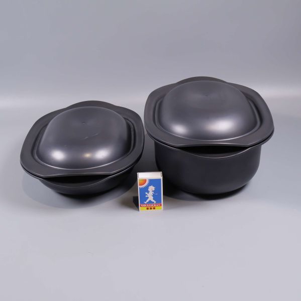 Två svarta gratängformar jämte tändsticksask för storleksjämförelse