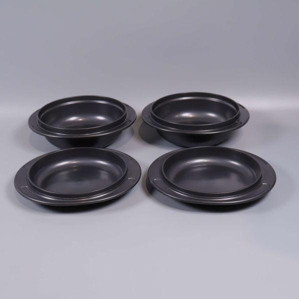 Fyra svarta runda skålar visas från ovan