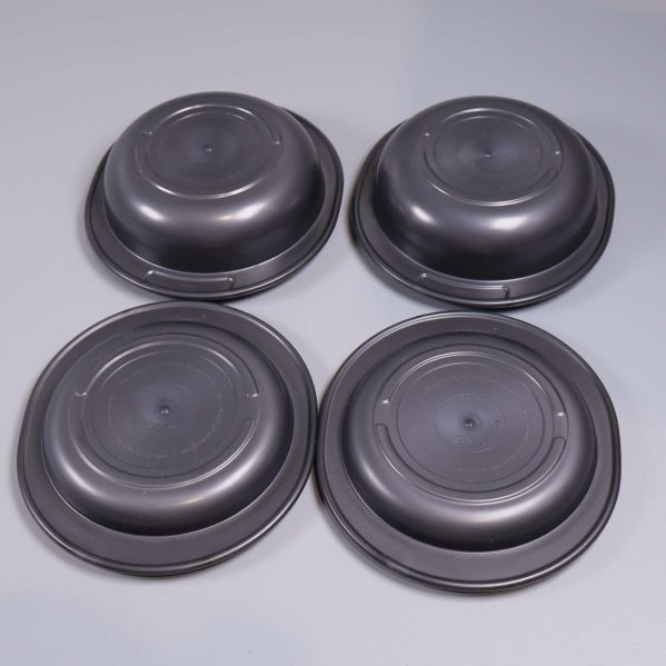 Fyra svarta skålar sedda underifrån med botten synlig