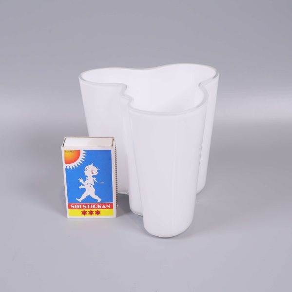 Vit vas placerad bredvid tändsticksask för storleksjämförelse