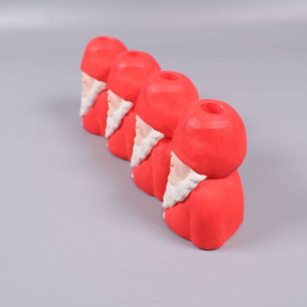 Ljusstake med fyra tomtar sedda snett bakifrån