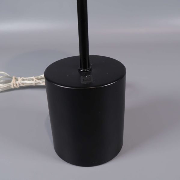 Närbild på lampans svarta cylinderformade fot