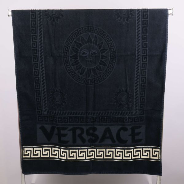 Handduk upphängd på stång med Versace-text