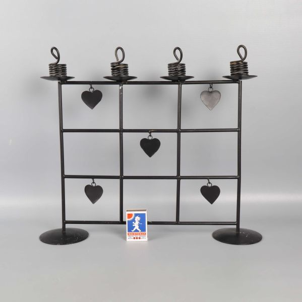 Framsida av svart ljusstake med hjärtan och tändsticksask för storleksreferens