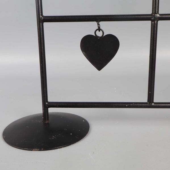 Närbild på bas och hängande hjärta på ljusstaken