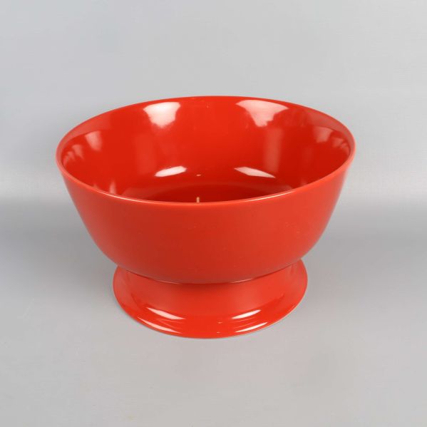 Röd skål med bred fot mot ljus bakgrund