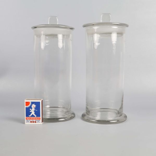 Två glasburkar bredvid ett tändsticksfodral för storleksjämförelse