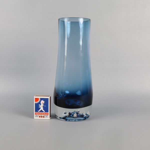 Blå glasvas jämte tändsticksask för storleksjämförelse