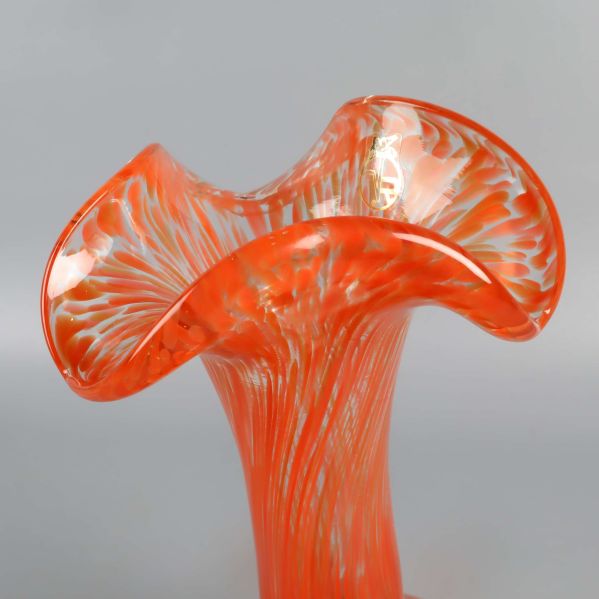 Närbild på vasens vågiga och färgstarka kant