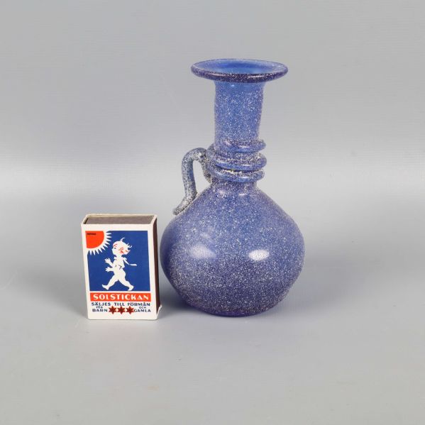 Blå liten vas  bredvid tändsticksask för storleksjämförelse