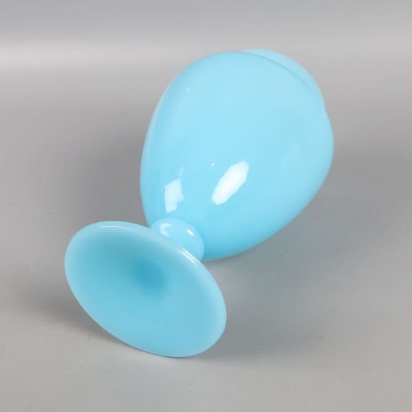 Blå vas liggande på sidan med synlig fot och öppning