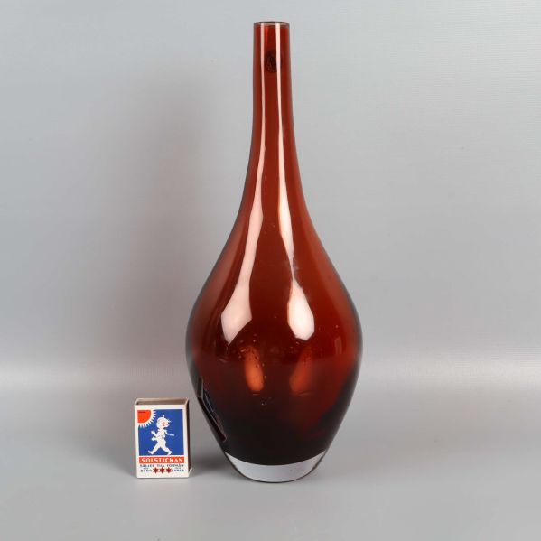 Glasvas placerad bredvid tändsticksask för storleksjämförelse