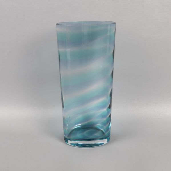 Cylindrisk blå glasvas mot ljus bakgrund