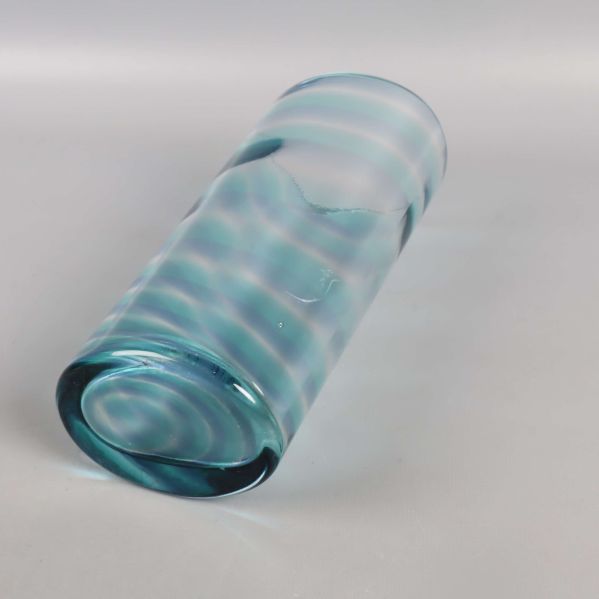 Blå glasvas liggande för att visa botten