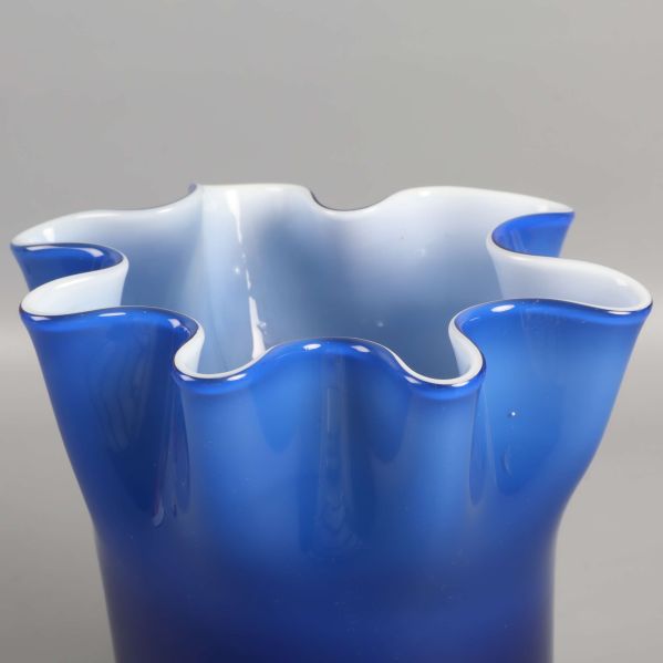 Närbild på kant av blå vas med vit insida