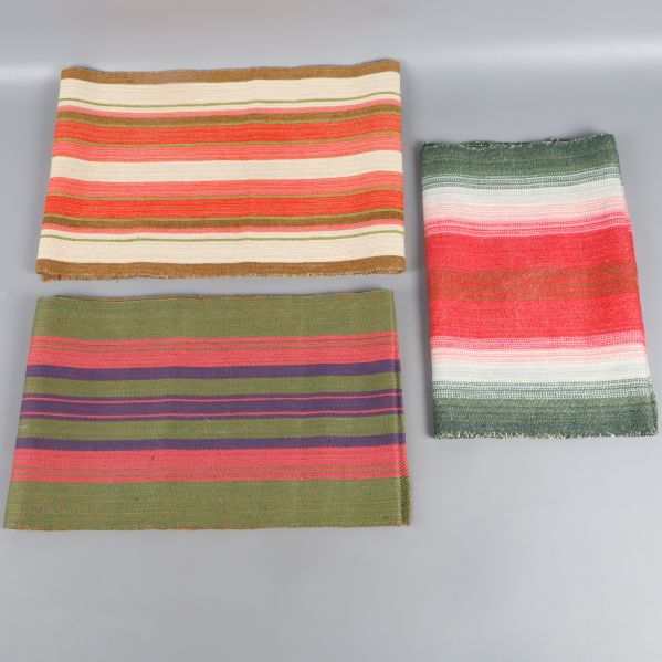 Tre färgglada löpare med randigt mönster, på rad