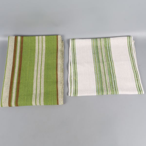 Två hopvikta löpare med gröna ränder på grå bakgrund