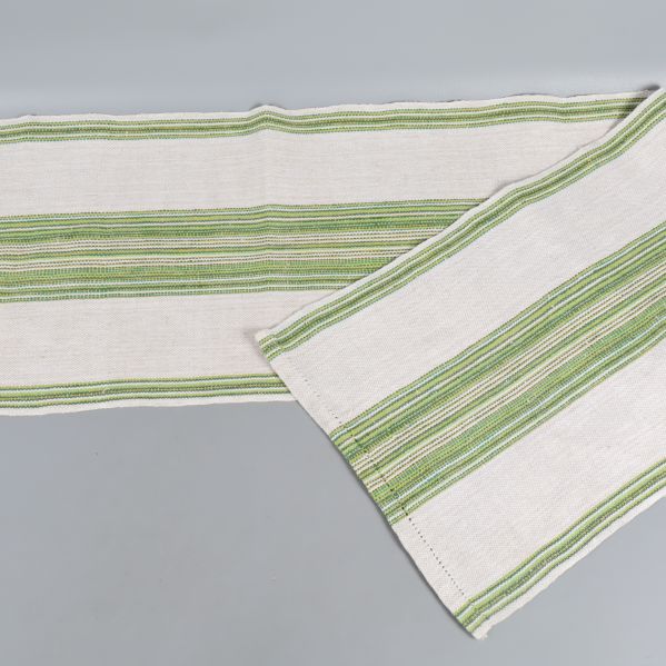 Vit löpare med gröna ränder utvikt på grått underlag