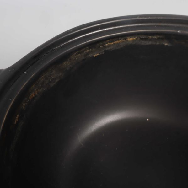 Närbild av grytas insida med användningsspår längs kanten