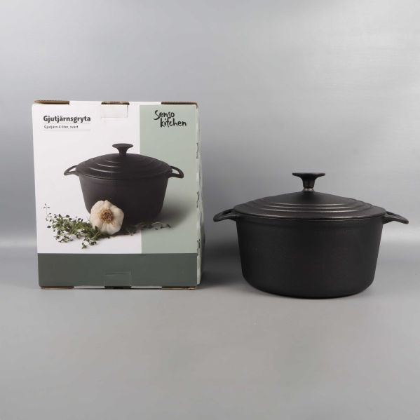 Svart gryta och produktlåda bredvid varandra