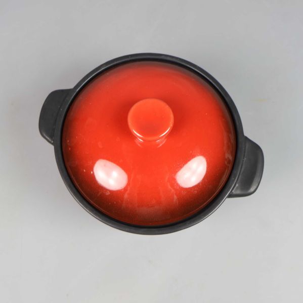 Gryta sedd uppifrån med rött lock på