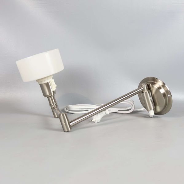 Vägglampa med metallarm och vit sladd mot grå bakgrund