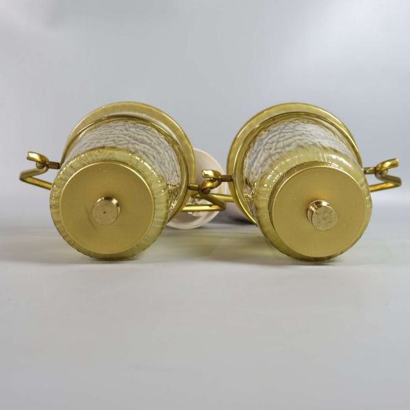 Botten av taklampornas guldfärgade metallfäste i närbild