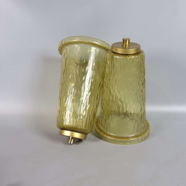 Två lösa lampskärmar av gultonat strukturerat glas liggandes